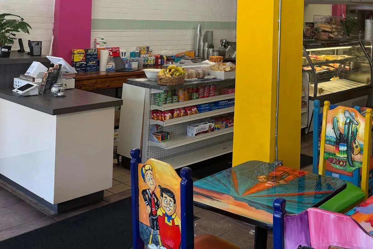 The deli dining room with yellow and pink columns, hand-painted Mexican chairs and tables, and the deli case